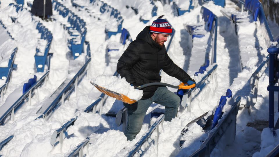 A man clears snow before the NFL wild-card playoff football game in Buffalo on January 15. - Jeffrey T. Barnes/AP