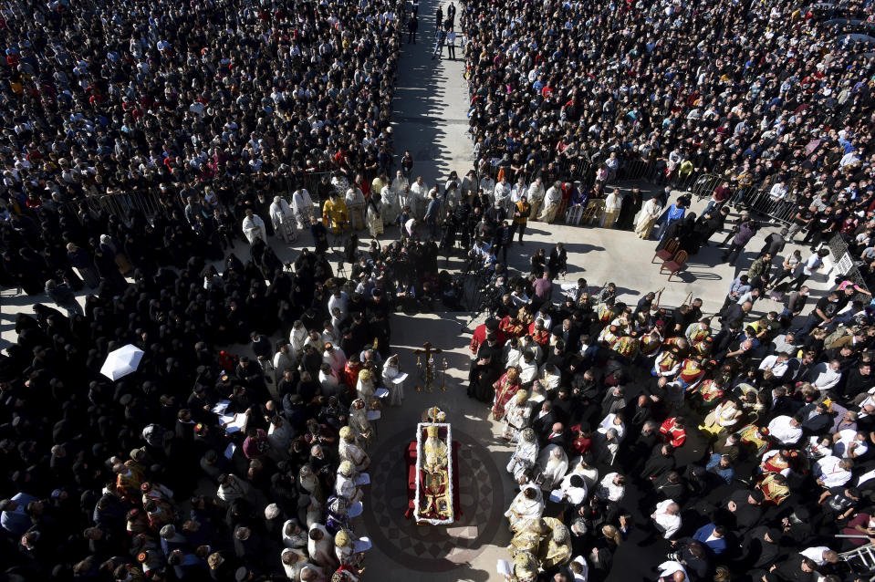 FILE - In this Sunday, Nov. 1, 2020 file photo, thousands gather by an open casket with the body of Bishop during the liturgy and and funeral outside the main temple in the capital Podgorica, Montenegro. The patriarch of the Serbian Orthodox Church has been hospitalized after testing positive for the new coronavirus. The diagnosis comes days after he led prayers at the large public funeral for the head of the church in Montenegro, who died after contracting the virus. The Serbian church announced late Wednesday, Nov. 4, 2020 that the 90-year-old Patriarch Irinej was hospitalized but has no symptoms and is in “excellent general condition.” (AP Photo/Risto Bozovic, File)