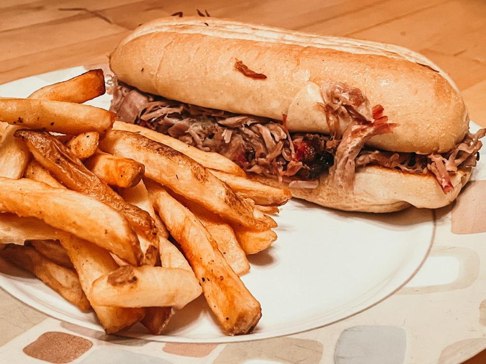 thick cut fries and a pulled pork sandwich on a kitchen plate