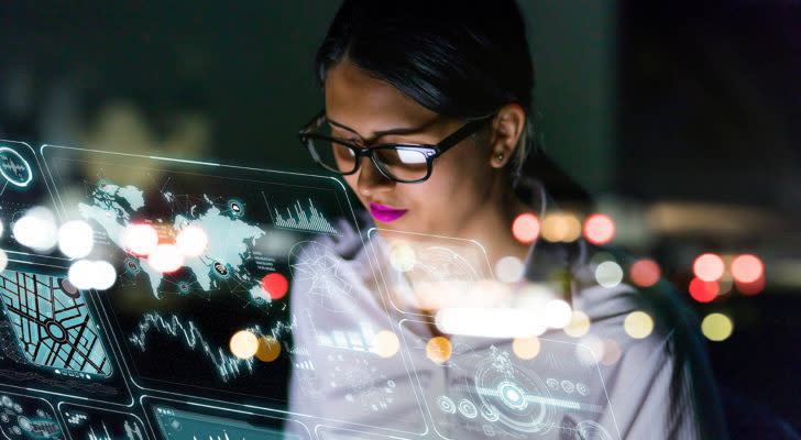 A businesswoman looks at a floating interface screen full of data representing SOPA Stock.