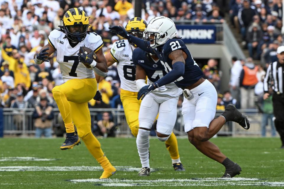 Michigan running back Donovan Edwards gains yardage while being chased by Penn State safety Kevin Winston Jr. during the first half in State College on Saturday, November 11, 2023.