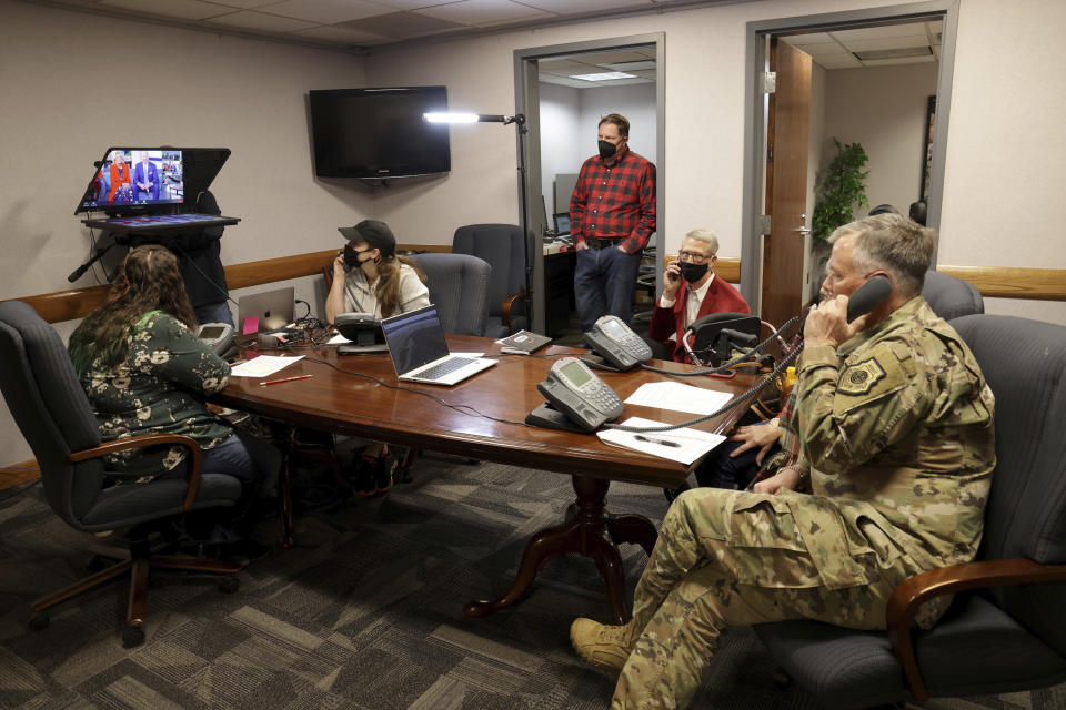 This image provided by the Department of Defense shows volunteers answering phones and emails from children around the globe during the annual NORAD Tracks Santa event on Peterson Air Force Base in Colorado Springs, Colo., Dec. 24, 2021. (Chuck Marsh/Department of Defense via AP)