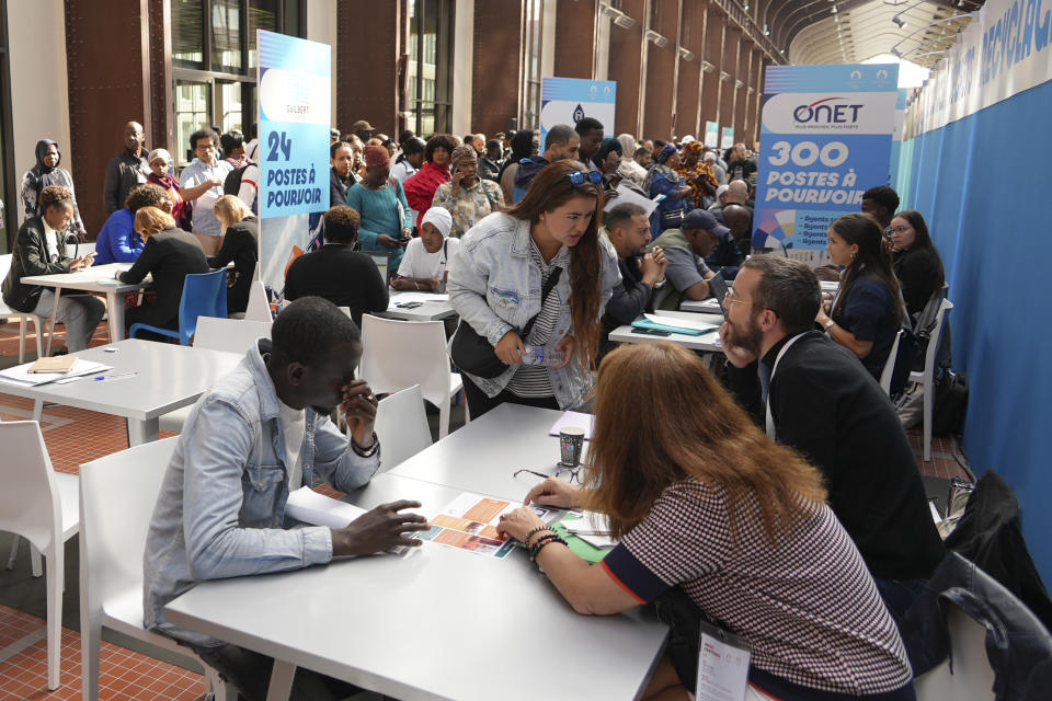 People queue for information or to apply for a job Tuesday, Sept. 26, 2023 in Saint-Denis, a northern suburb of Paris. Paris Olympics organizers and their partners organized a giant job fair meant to help filling about 16,000 vacancies in key sectors including catering, security, transport and cleaning. About 50 companies are recruiting to be able to welcome next year millions of spectators and 14,500 athletes. (AP Photo/Nicolas Garriga)