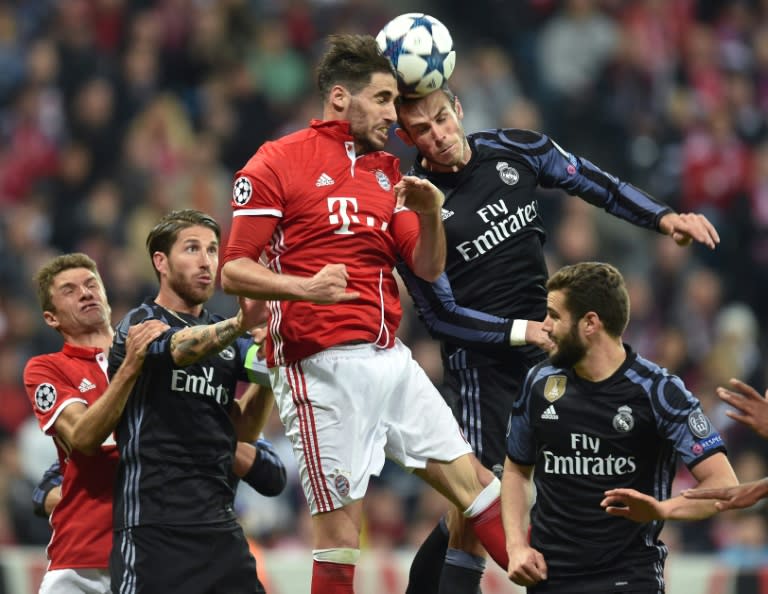 Bayern Munich's midfielder Javi Martinez (top L) and Real Madrid's midfielder Toni Kroos (top R) vie for the ball during the UEFA Champions League 1st leg quarter-final football match April 12, 2017