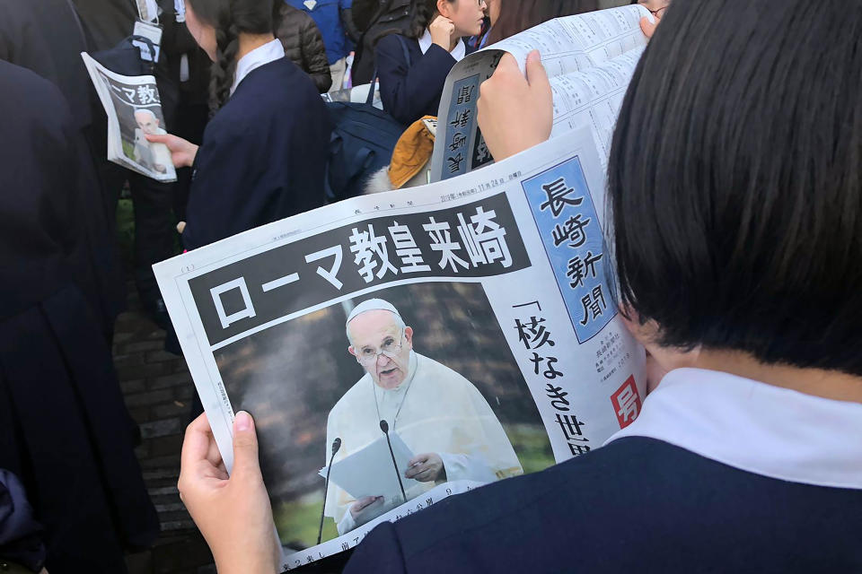 An extra newspaper on Pope Francis visiting Nagasaki is handed out to public after a Mass, Sunday, Nov. 24, 2019, in Nagasaki, Japan. (AP Photo/Haruka Nuga)