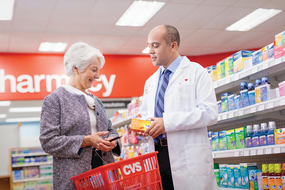 A CVS pharmacist discussing products with a customer.