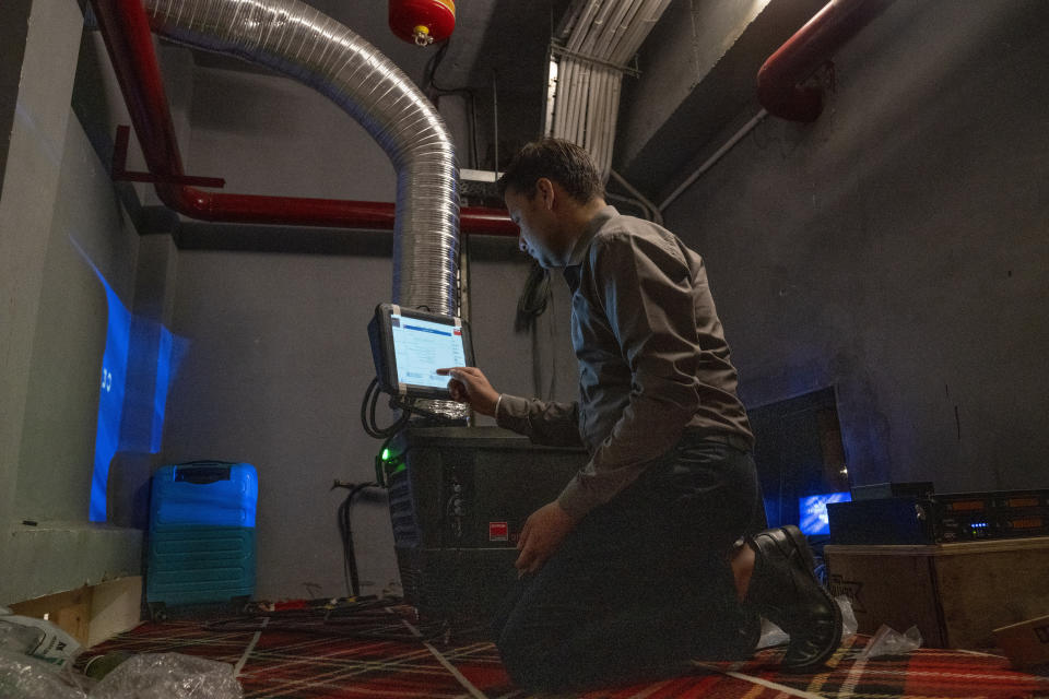 An engineer tests a projector at the newly constructed 'INOX' multiplex in Srinagar, Indian controlled Kashmir, Monday, Sept. 19, 2022. The multi-screen cinema hall has opened in the main city of Indian-controlled Kashmir for public for the first time in 14 years. The 520-seat hall with three screens opened on Saturday, Oct. 1, amid elaborate security but only about a dozen viewers lined up for the first morning show. (AP Photo/Dar Yasin)