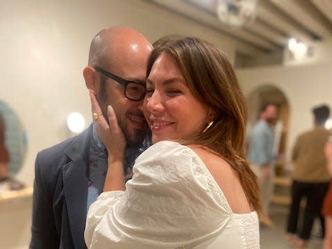 Sophia Benoit wearing a white dress and hugging her partner