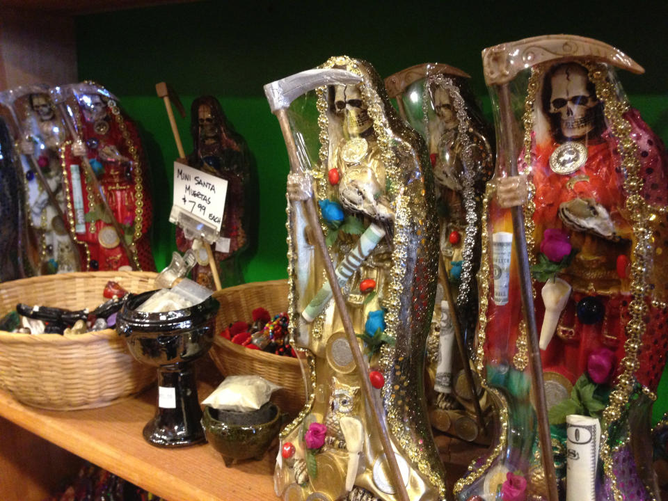 FILE - In this Feb. 13, 2013 file photo, statues of La Santa Muerte are shown at the Masks y Mas art store in Albuquerque, N.M. As “Breaking Bad” finishes filming its fifth and final season in Albuquerque, the popularity of the show is providing a boost to the economy and creating a dilemma for local tourism officials as they walk the fine line of profiting from a show that centers around drug trafficking, addiction and violence. The store provided the statues used in the chilling opening scene of the show’s third season, in which a pair of cartel assassins crawl to the saint’s shrine in Mexico to request some divine help. (AP Photo/Russell Contreras, File)