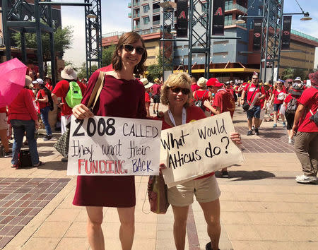 Participants hold placards during a march in Phoenix, Arizonia, U.S., April 26, 2018 in this picture obtained from social media. Christy Chavis/via REUTERS