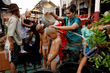 Boys are bathed with scented water in preparation for an annual Poy Sang Long celebration, a traditional rite of passage for boys to be initiated as Buddhist novices, in Mae Hong Son, Thailand April 2, 2018. REUTERS/Jorge Silva