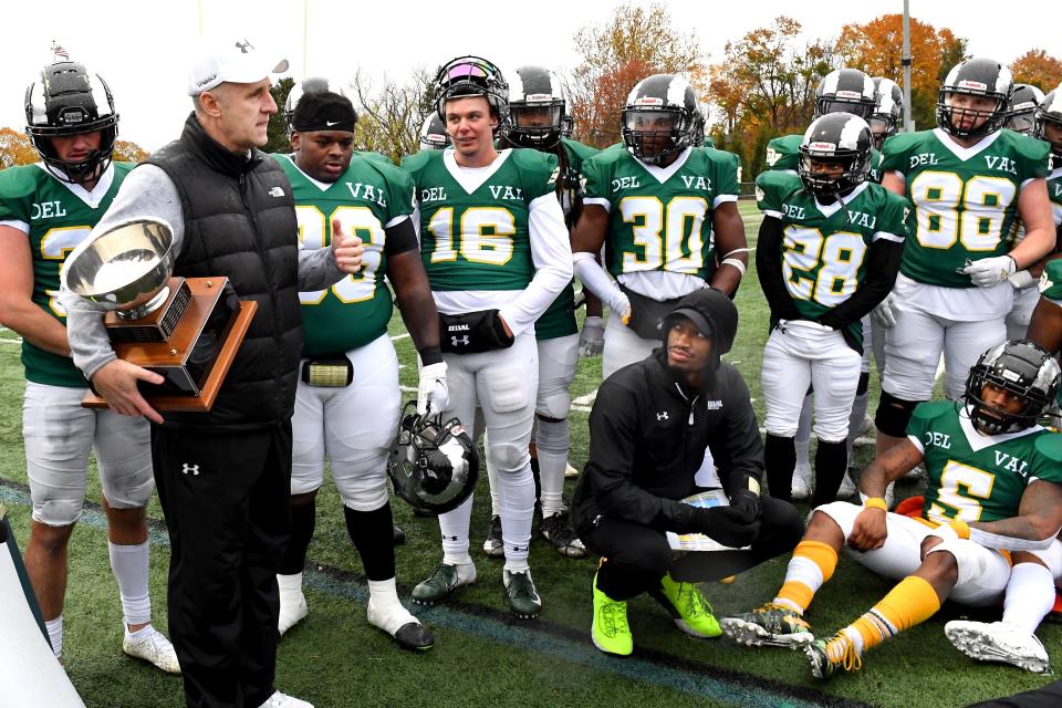 DelVal coach Duke Greco, holding the Keystone Cup, talks to the Aggies after their 27-0 win over Widener in 2021.