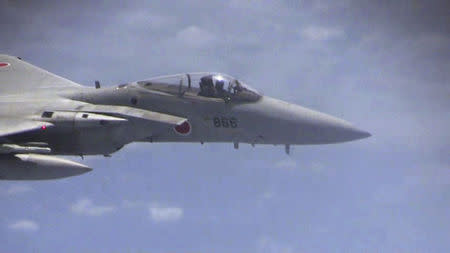 A Japanese F-15 jet flies over the East China Sea, in this still image from video footage released by China's Ministry of Defense on June 12, 2014. China said on Thursday that Japan's accusations of Chinese fighter jets flying "abnormally close" to Japanese military aircraft over the East China Sea were aimed at deceiving the international community. REUTERS/Ministry of National Defense of the People's Republic of China/via Reuters TV