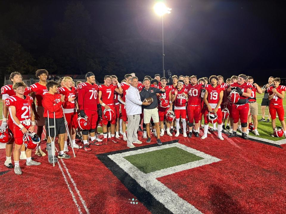 Indian Hill head coach John Rodenberg is presented with the game ball from his 200th career win after the Braves beat Mariemont 35-21 on Friday, September 8, 2023 at Tomahawk Stadium.