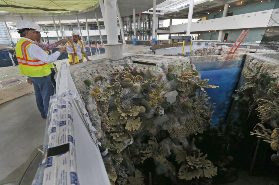 In this Thursday, Dec. 8, 2016 photo, Frank Steslow, foreground, president of the Patricia and Phillip Frost Museum of Science, points out the progress in construction during a tour of the museum in Miami. Rising next to Miami's spiffy new bayside art museum is a $305 million science museum that, like South Florida, is focused in large part on water: its centerpiece is a 500,000-gallon aquarium that will feature sharks, tuna, mahi-mahi and even sea turtles, with other smaller tanks for corals and other sea life. The Frost Science Museum, scheduled to open this spring. (AP Photo/Wilfredo Lee)