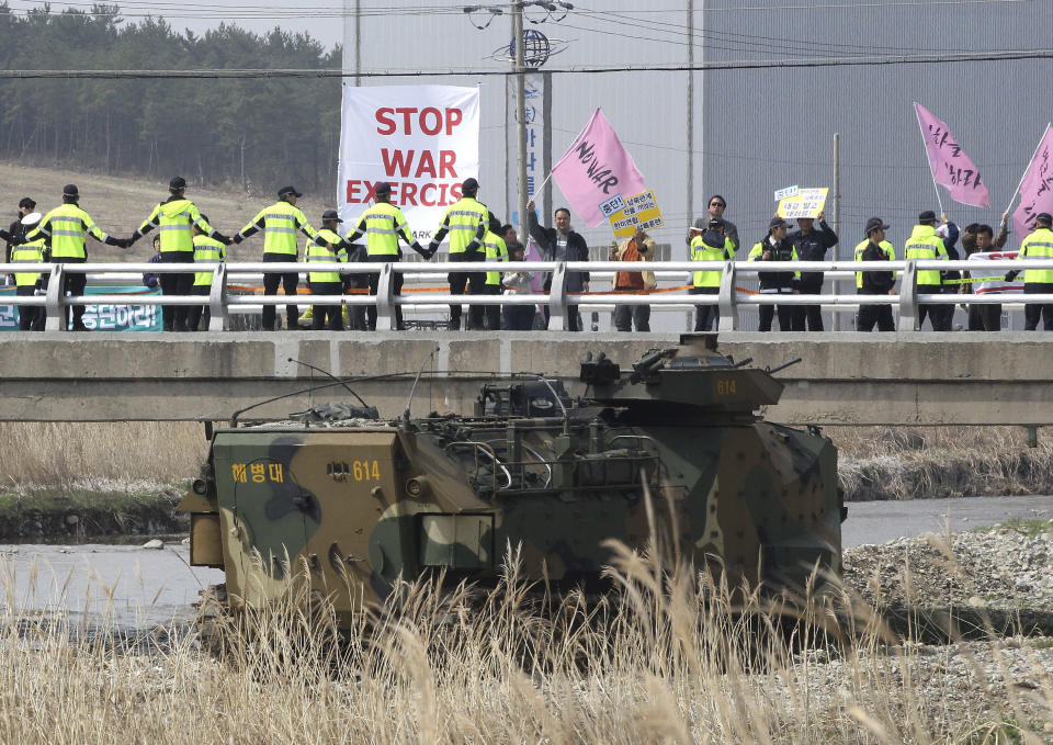 Anti-war protesters stage a rally during the U.S.-South Korea joint landing exercises called Ssangyong as part of the Foal Eagle military exercises in Pohang, South Korea, Monday, March 31, 2014. South Korea on Monday returned fire into North Korean waters after shells from a North Korean live-fire drill fell south of the rivals' disputed western sea boundary, a South Korean military official said. (AP Photo/Ahn Young-joon)