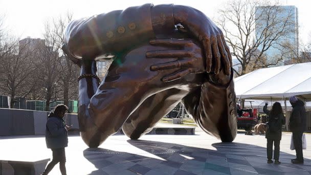 PHOTO: Passers-by walk near the 20-foot-high bronze sculpture 'The Embrace,' a memorial to Dr. Martin Luther King Jr. and Coretta Scott King, in the Boston Common, Jan. 10, 2023, in Boston. (Steven Senne/AP)