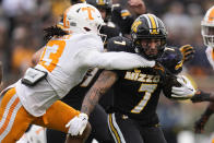 Missouri running back Cody Schrader (7) runs with the ball as Tennessee defensive back Wesley Walker defends during the first half of an NCAA college football game Saturday, Nov. 11, 2023, in Columbia, Mo. (AP Photo/Jeff Roberson)