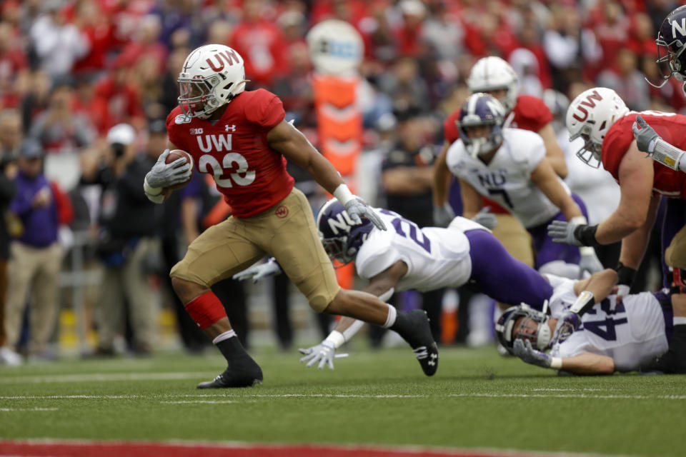 Wisconsin running back Jonathan Taylor (23) run for a touchdown against Northwestern defensive back Brian Bullock (26) and Northwestern linebacker Paddy Fisher (42) during the first half of an NCAA college football game Saturday, Sept. 28, 2019, in Madison, Wis. (AP Photo/Andy Manis)