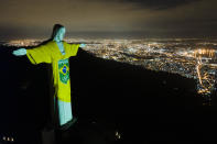 The colors of the Brazilian Olympic team are projected on the statue of Christ the Redeemer by the Brazilian Olympic Committee as a reminder of how sport can inspire in the fight against COVID-19, one hundred days before the Tokyo Olympic Games, in Rio de Janeiro, Brazil, Wednesday, April 14, 2021. (AP Photo/Lucas Dumphreys)