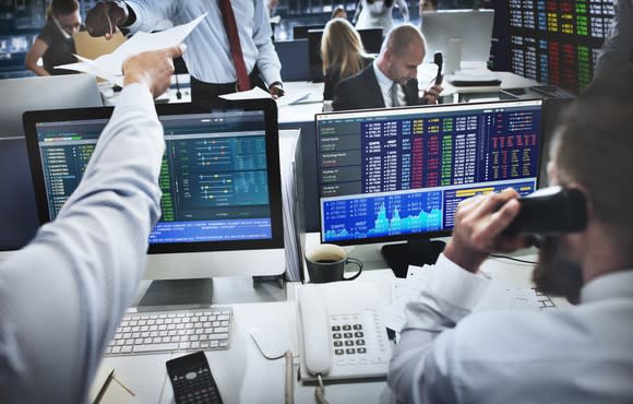 Institutional investors actively trading at their desks.