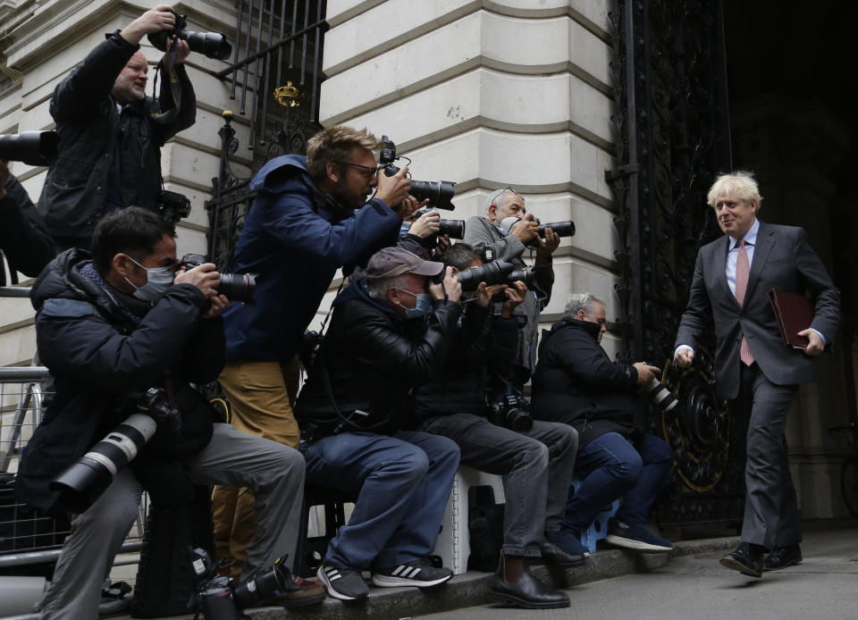 Britain's Prime Minister Boris Johnson returns to 10 Downing Street following a cabinet meeting, held in the Foreign Office to allow for social distancing due to the coronavirus outbreak, in London, Wednesday, Sept. 30, 2020. (AP Photo/Alastair Grant)