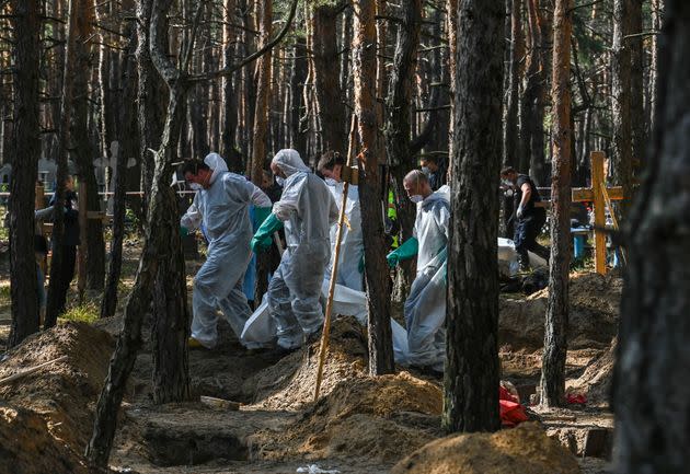 Forensic technicians investigate a mass grave site in a forest near Izium, in eastern Ukraine, on September 18, 2022. (Photo: JUAN BARRETO via Getty Images)