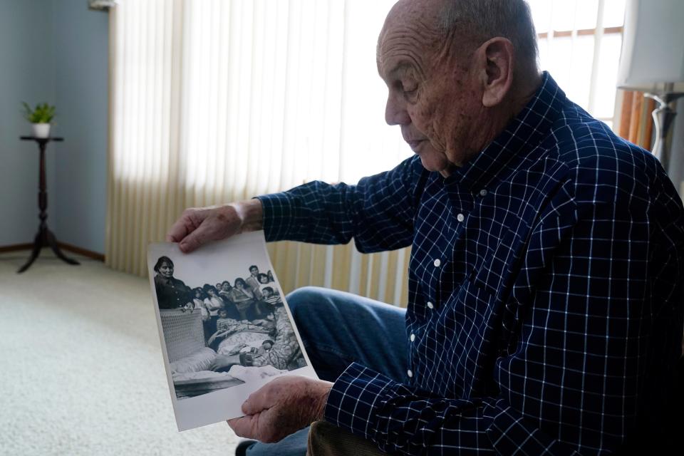 Retired Associated Press Photographer Jim Mone shows a print of a photo taken from his coverage at Wounded Knee, Friday, Feb. 24, 2023, in Bloomington, Minn. On Feb. 27, 1973, members of the American Indian Movement took over the town of Wounded Knee, starting a 71-day occupation on the Pine Ridge Indian Reservation in South Dakota. Mone was there to capture images of the standoff as it stretched into weeks. (AP Photo/Abbie Parr)