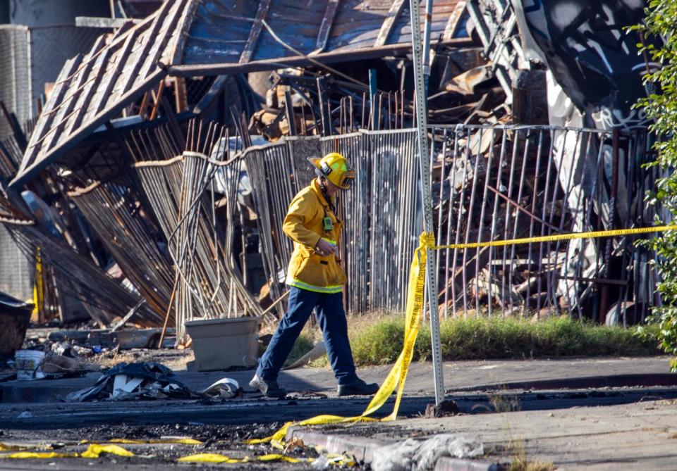 Los Angeles firefighters assess the fire damage to the 10 Freeway