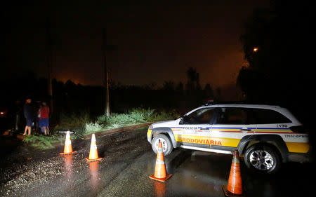 Police officers block a road close to the area of the B3/B4 mine operated by Vale SA that was evacuated, in Nova Lima, Brazil February 16, 2019. REUTERS/Cristiane Mattos