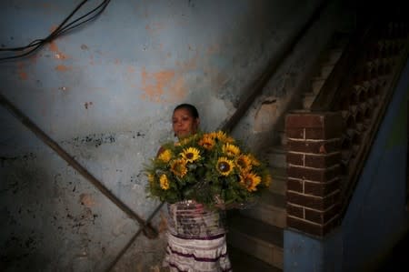 Yolanda Sanchez, 44, carries flowers from her home to be sold on the street in downtown Havana, March 19, 2016. REUTERS/Alexandre Meneghini