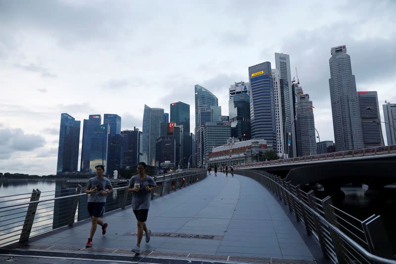 Joggers run near the Merlion Park in Singapore as the city state reopens the economy amid the coronavirus disease (COVID-19) outbreak