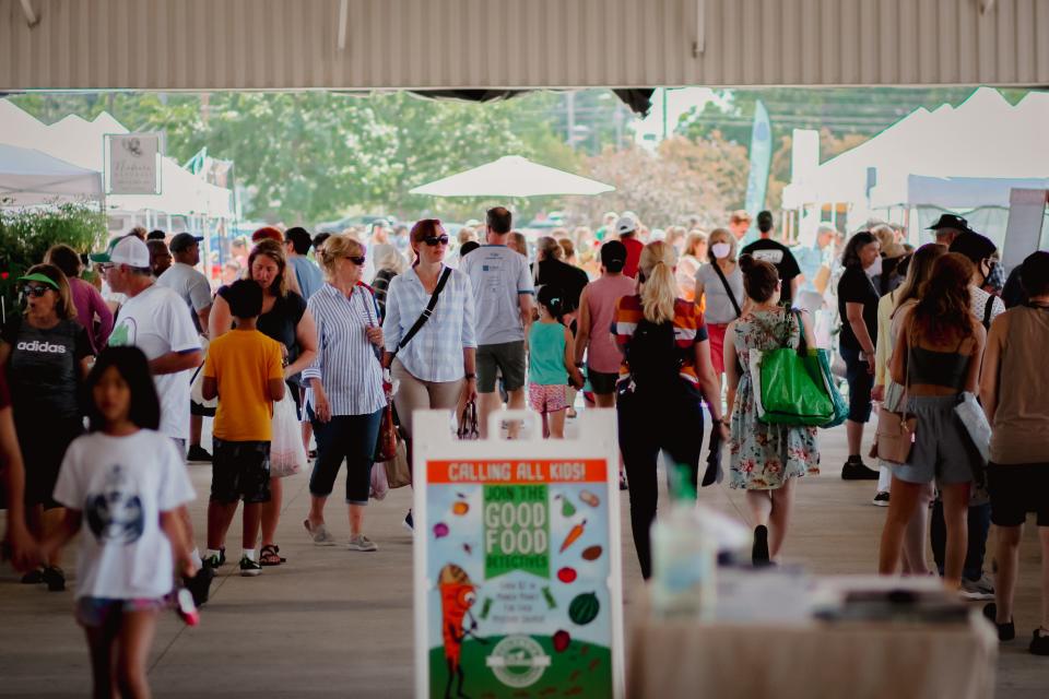 People walk around the Columbia Farmers Market.