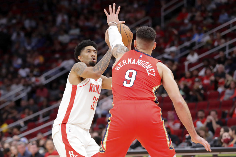 Houston Rockets center Christian Wood (35) looks to shoot past New Orleans Pelicans center Willy Hernangomez (9) during the first half of an NBA basketball game Sunday, Dec. 5, 2021, in Houston. (AP Photo/Michael Wyke)