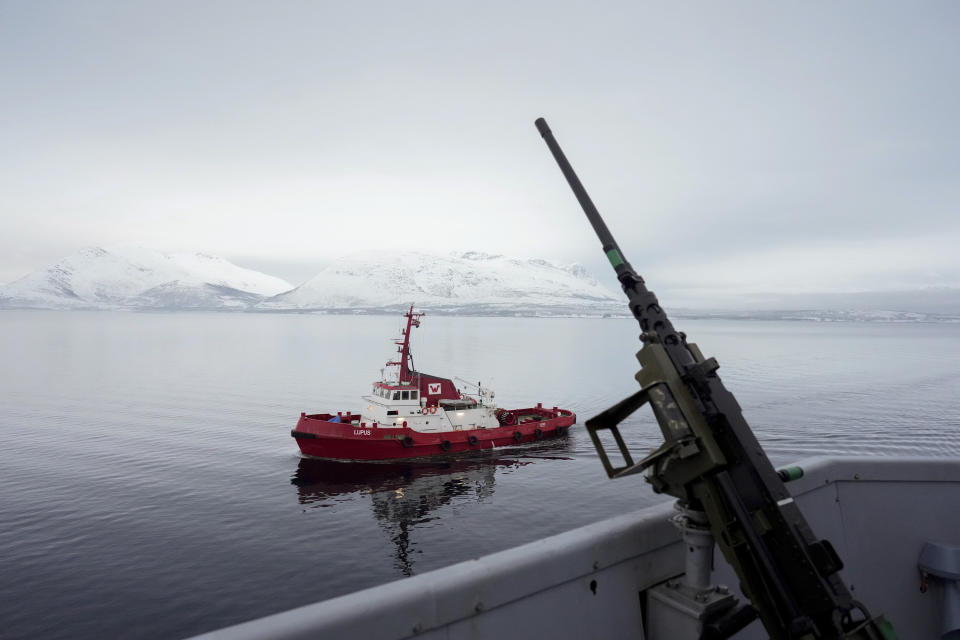 A tugboat sails alongside the French navy frigate Normandie before it docks during a patrol in a Norwegian fjord, north of the Arctic circle, Friday March 8, 2024. The French frigate is part of a NATO force conducting exercises in the seas, north of Norway, codenamed Steadfast Defender, which are the largest conducted by the 31 nation military alliance since the cold war. (AP Photo/Thibault Camus)