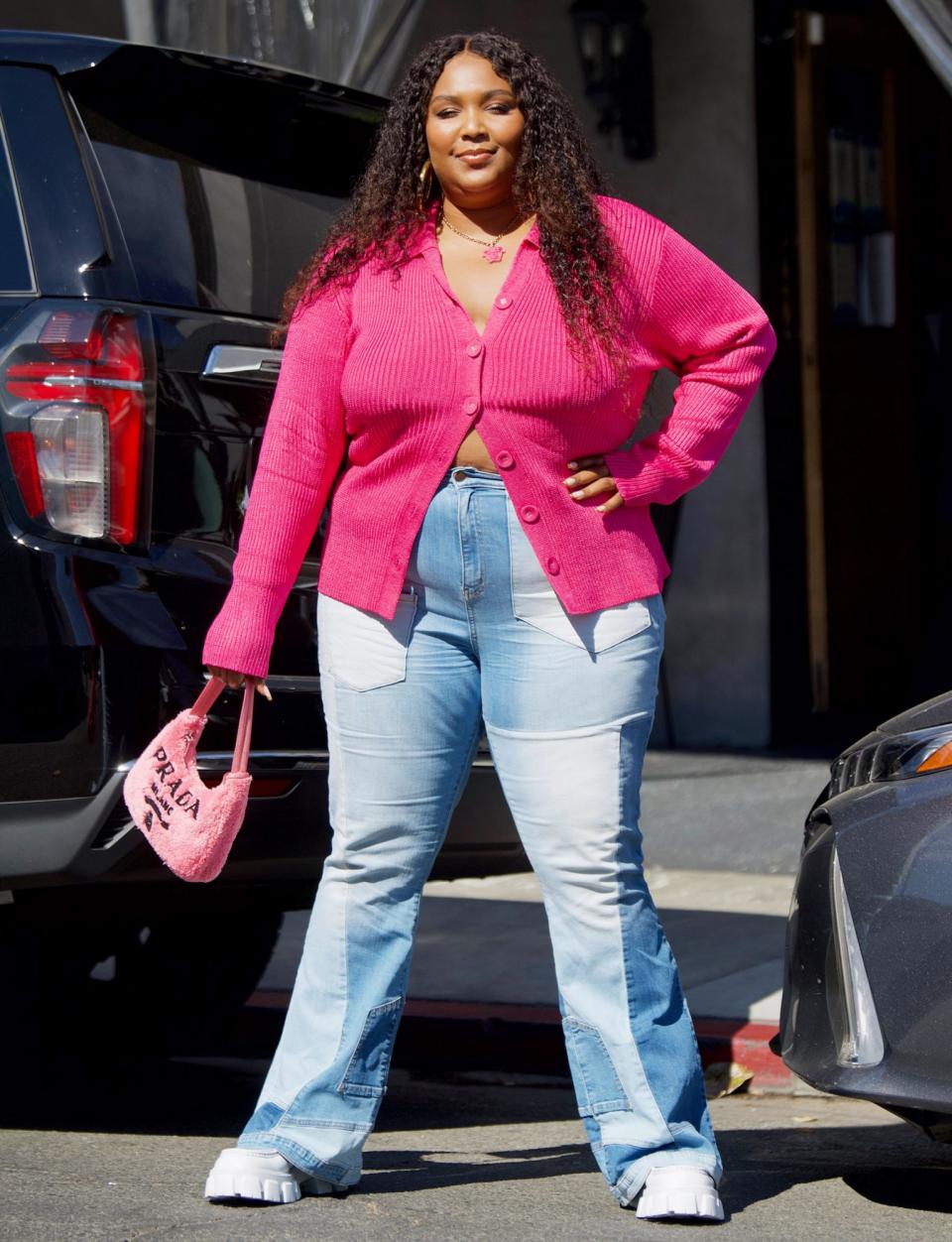 <p>Lizzo shows off her street style in a pink cardigan, pink Prada bag and patchwork denim on June 6 after grabbing lunch in L.A. </p>