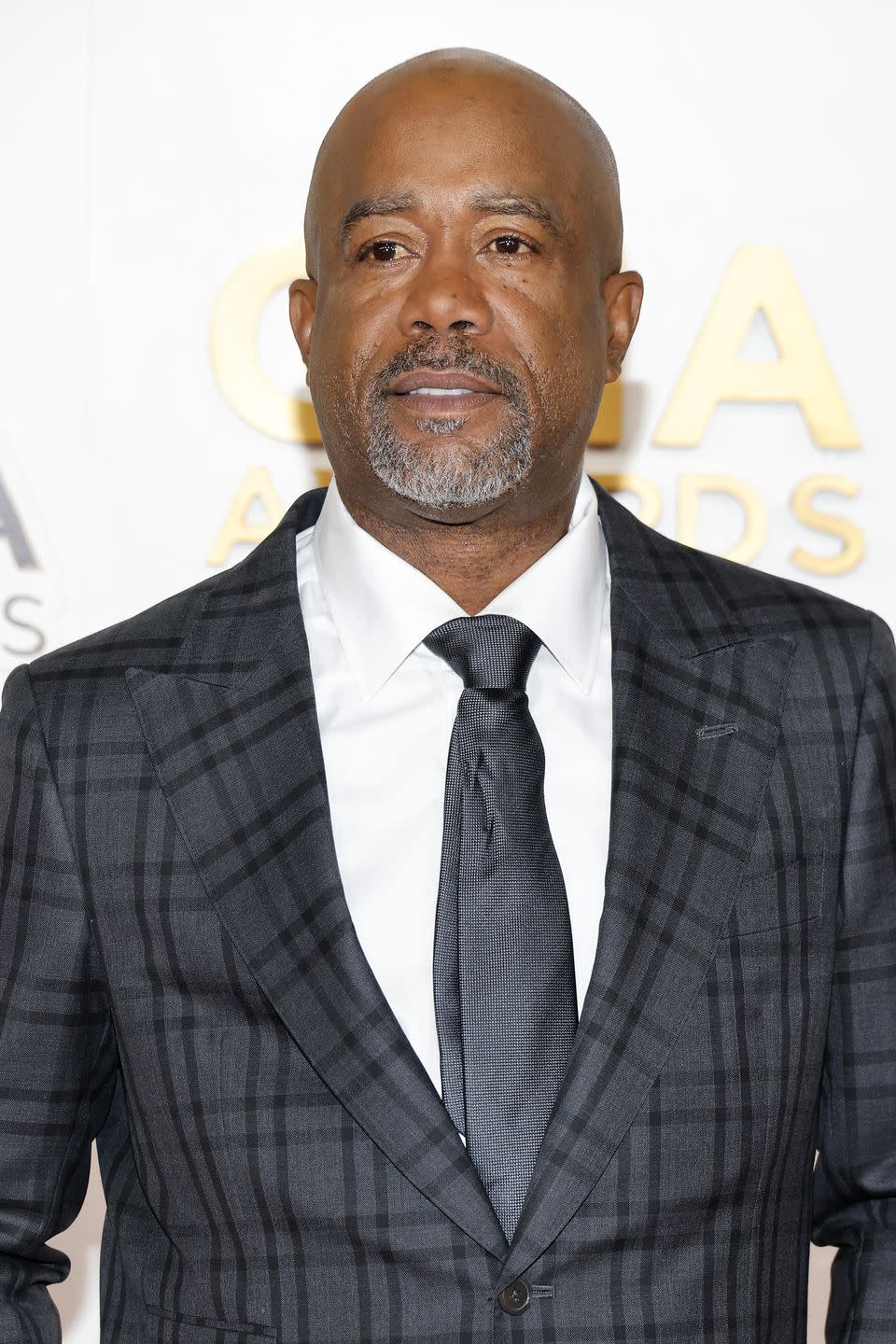 darius rucker wearing a black striped suit and tie and posing for photos at the cma awards