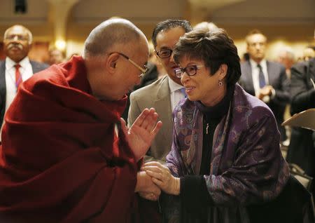 The Dalai Lama shakes hands with Valerie Jarrett, senior advisor to U.S. President Barack Obama, at the National Prayer Breakfast in Washington, February 5, 2014. REUTERS/Kevin Lamarque