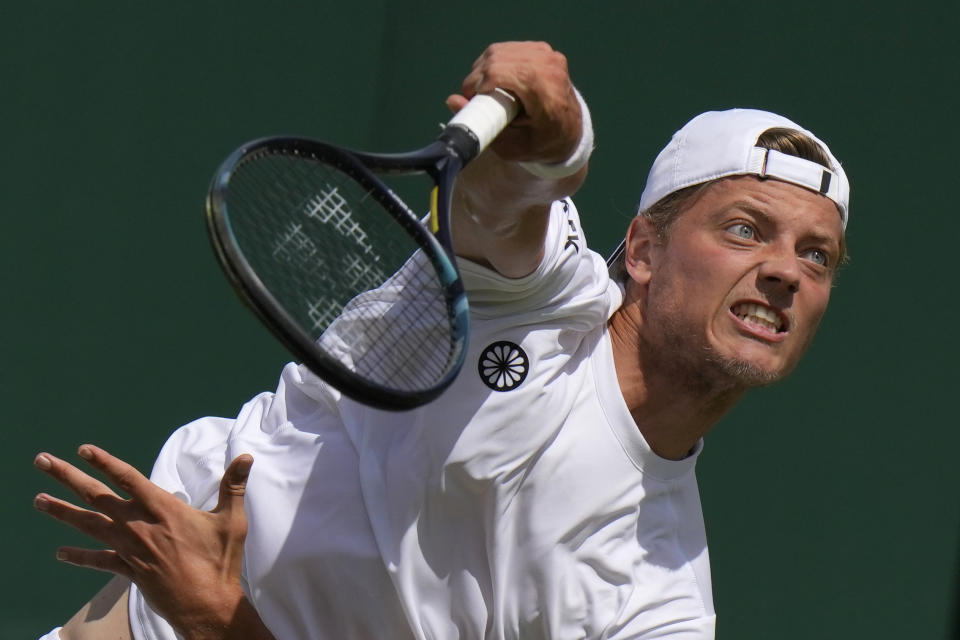 Tim van Rijthoven of the Netherlands serves to Georgia's Nikoloz Basilashvili in a third round men's singles match on day five of the Wimbledon tennis championships in London, Friday, July 1, 2022. (AP Photo/Alastair Grant)