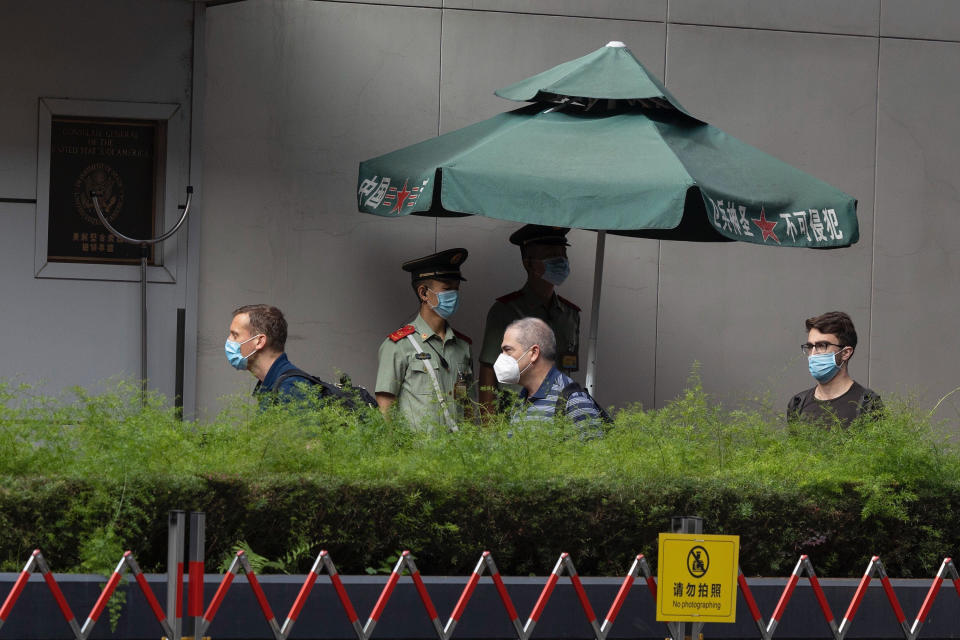 Chinese paramilitary policemen look on as consular staff walk past the United States Consulate in Chengdu in southwest China's Sichuan province on Sunday, July 26, 2020. China ordered the United States on Friday to close its consulate in the western city of Chengdu, ratcheting up a diplomatic conflict at a time when relations have sunk to their lowest level in decades. (AP Photo/Ng Han Guan)