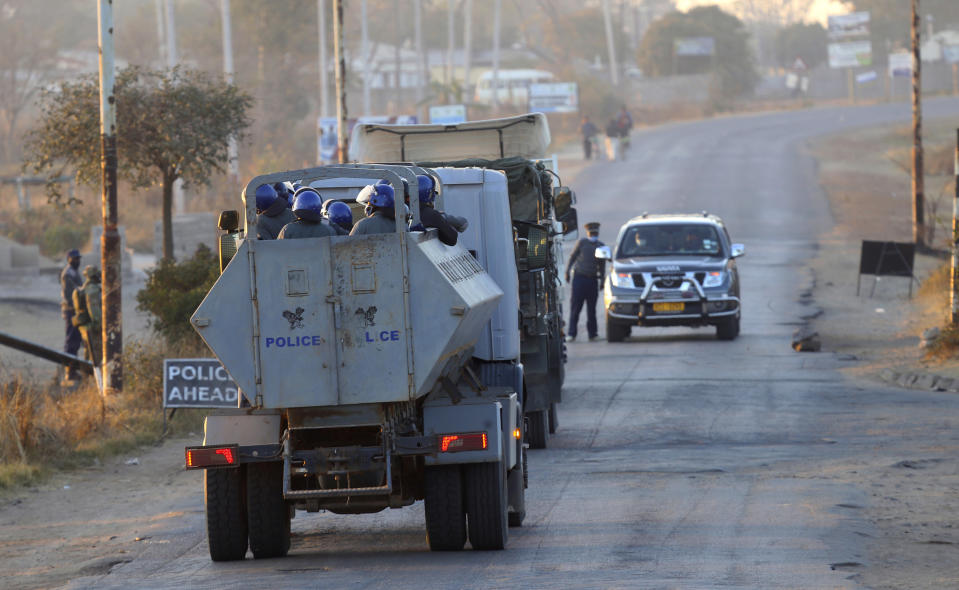 A truck carrying police enters a neighbourhood in Harare, Friday, July, 31, 2020. Zimbabwe's capital, Harare, was deserted Friday, as security agents vigorously enforced the country's lockdown amidst planned protests. Police and soldiers manned checkpoints and ordered people seeking to get into the city for work and other chores to return home. (AP Photo/Tsvangirayi Mukwazhi)