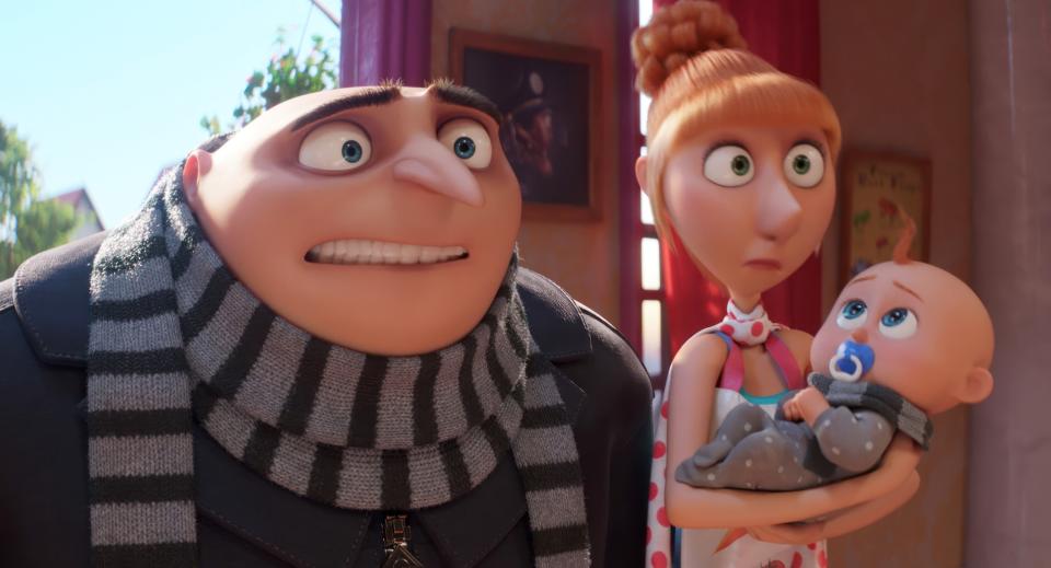 Gru, Lucy, and a baby from "Despicable Me," looking surprised. Lucy holds the baby; Gru wears a striped scarf