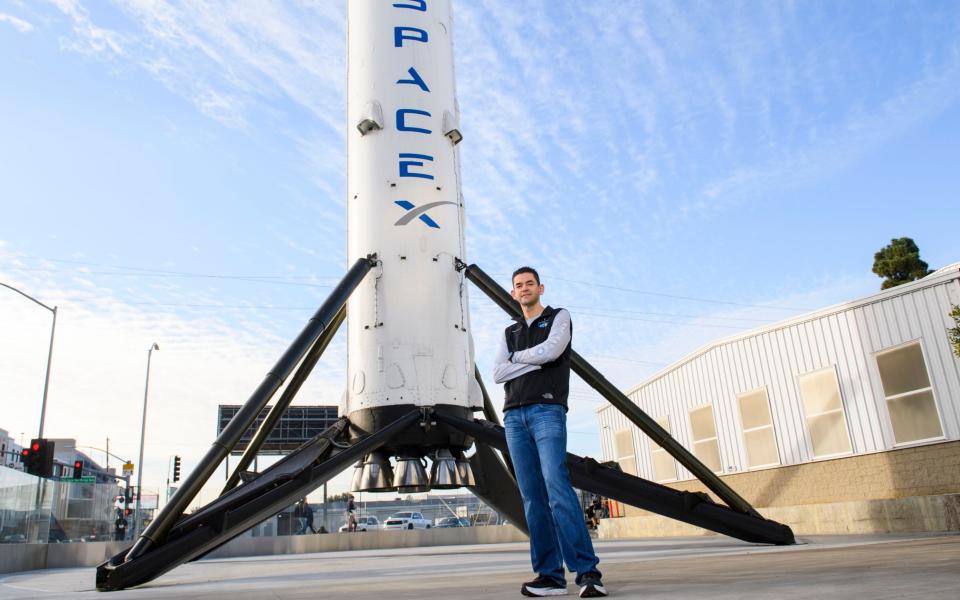 Inspiration4 mission commander Jared Isaacman, founder and chief executive officer of Shift4 Payments, stands for a portrait in front of the recovered first stage of a Falcon 9 rocket  - PATRICK T. FALLON /AFP