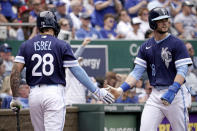 Kansas City Royals' Andrew Benintendi (16) celebrates with Kyle Isbel Kansas after scoring on a double by Carlos Santana during the third inning of a baseball game against the New York Yankees Sunday, May 1, 2022, in Kansas City, Mo. (AP Photo/Charlie Riedel)