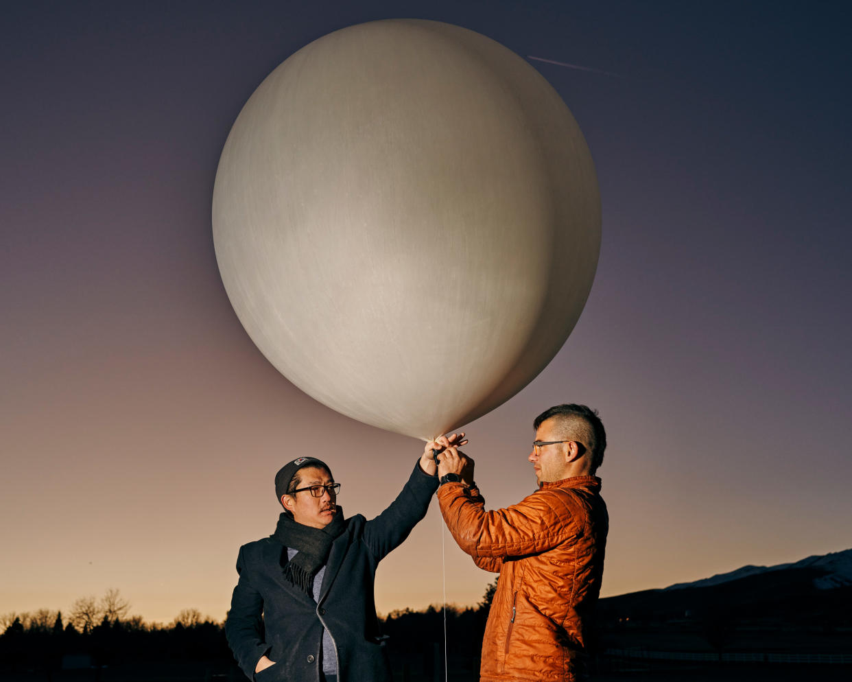 Founder Luke Iseman and co-founder Andrew Song of solar geoengineering startup Make Sunsets hold a weather balloon filled with helium, air and sulfur dioxide at a park in Reno, Nevada, United States on February 12, 2023.