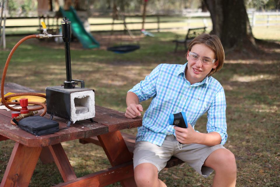 Landon Huber, 12, poses for a photo with his blacksmithing forge in his backyard on Wednesday, Oct. 12, 2022.