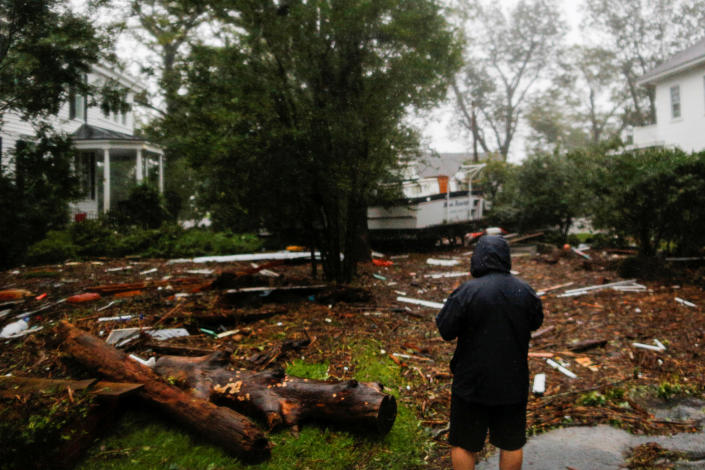<p>A man looks at a boat in a backyard after it was pushed away from the dock during the passing of Hurricane Florence in the town of New Bern, N.C., Sept. 14, 2018. (Photo: Eduardo Munoz/Reuters) </p>