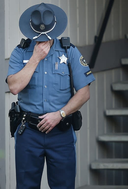 A police officer stands guard outside the apartment building where the alleged gunman Chris Harper Mercer lived in Roseburg, Oregon on October 2, 2015