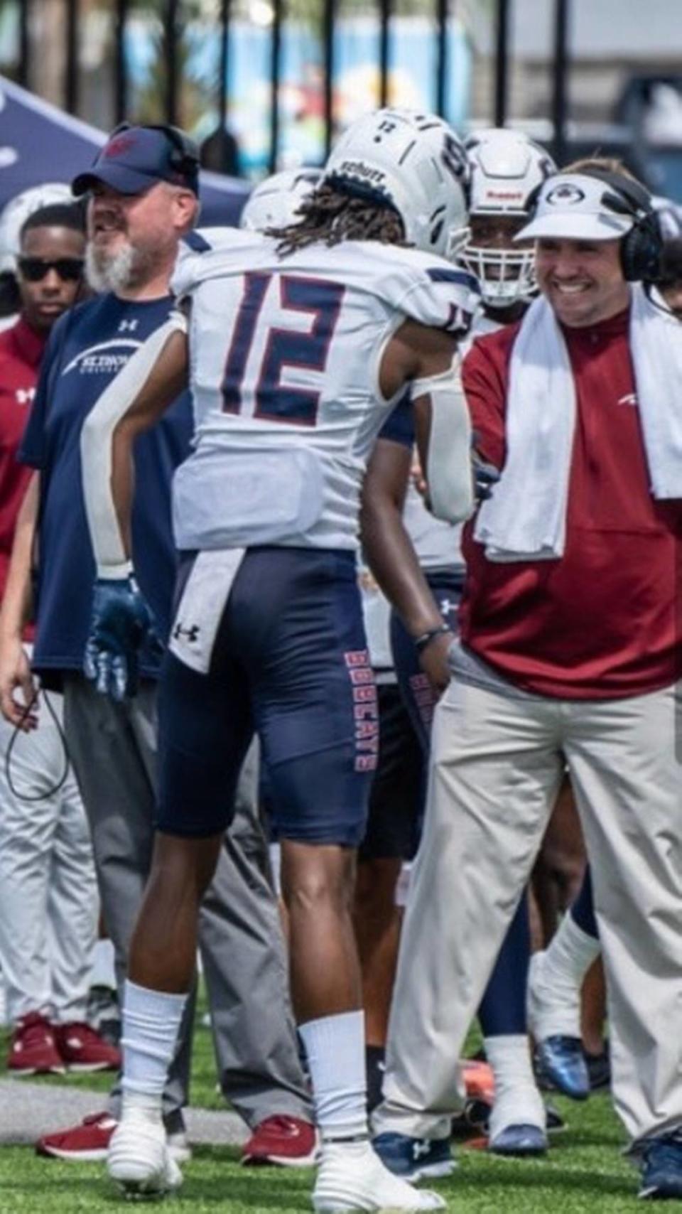 Drew Davis, assistant coach at St. Thomas University and son of former University of Miami and FIU football coach Butch Davis, greets one of his players during a game.