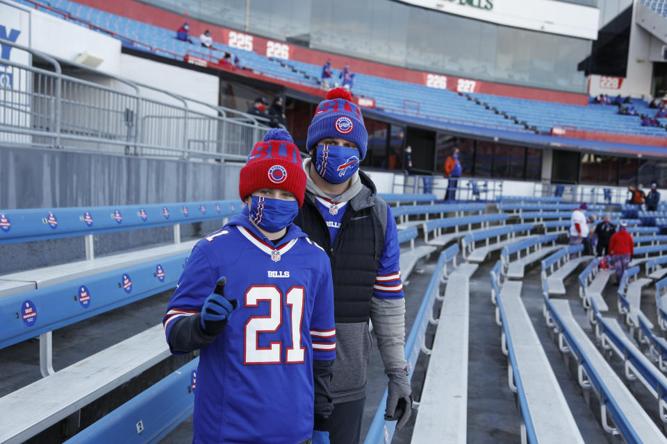 Buffalo Bills fans Scott Hammond, right, and his son Landon pose for a photograph as their team warms up before an NFL wild-card playoff football game against the Indianapolis Colts Saturday, Jan. 9, 2021, in Orchard Park, N.Y. The Hammonds were among the lucky 6,700 few to land tickets for the Bills wild-card playoff against the Colts for Buffalo's first home playoff game in 24 years. (AP Photo/Jeffrey T. Barnes)